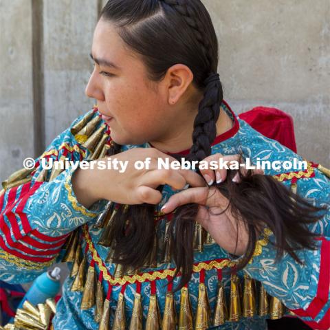 Alicia Scholfield braids her hair before the start of the UNITE powwow. Scholfield's family traveled from Kansas to attend. 2022 UNITE powwow to honor graduates (K through college). Held April 23 on the greenspace along 17th Street, immediately west of the Willa Cather Dining Center. This was UNITE’s first powwow in three years. The MC was Craig Cleveland Jr. Arena director was Mike Wolfe Sr. Host Northern Drum was Standing Horse. Host Southern Drum was Omaha White Tail. Head Woman Dancer was Kaira Wolfe. Head Man Dancer was Scott Aldrich. Special contest was a Potato Dance. April 23, 2023. Photo by Troy Fedderson / University Communication.